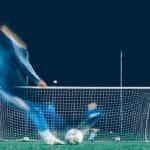 A timelapse photo of a player attempting a kick into a soccer goal.