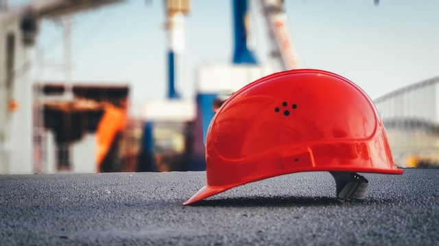 A worker’s hard hat helmet sitting on the ground of a construction site.